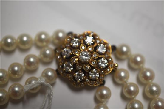 A 1980s triple strand cultured pearl choker necklace with 18ct gold and diamond cluster set clasp, 36cm.